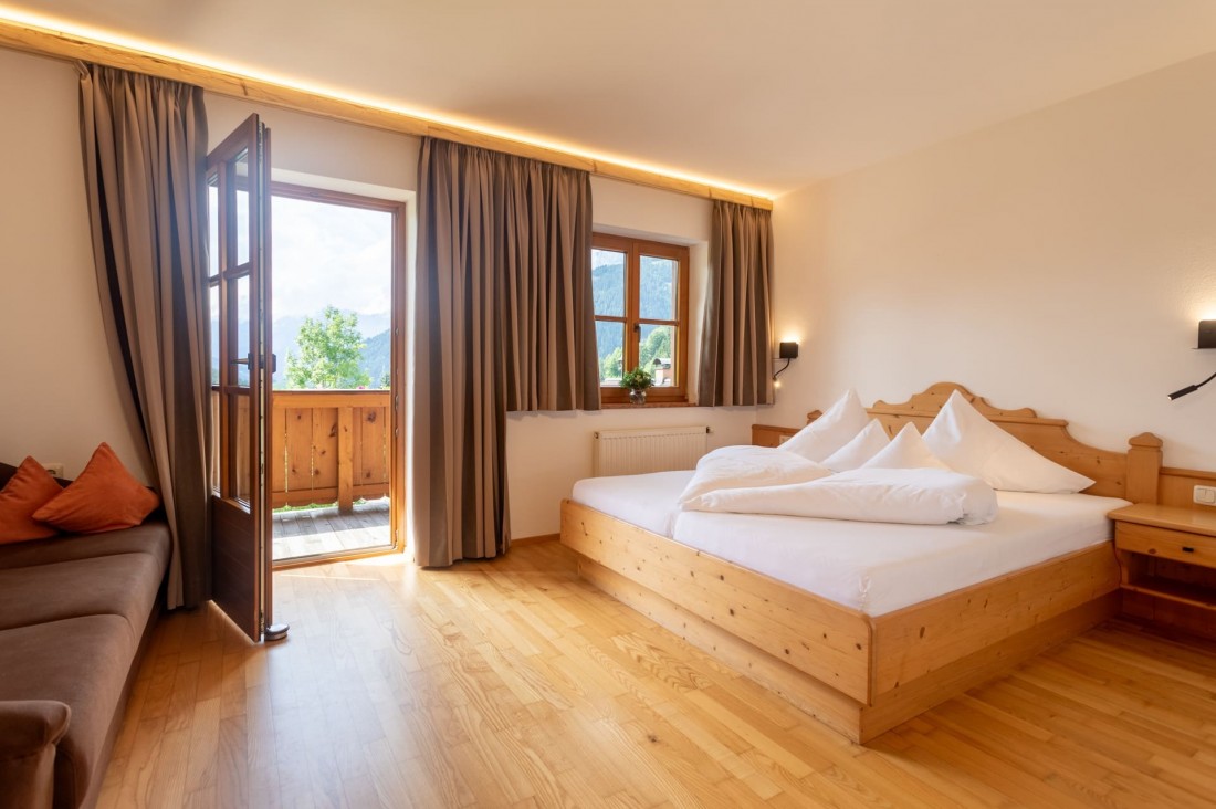 Schlafzimmer mit Doppelbett und Balkon mit Abendsonne