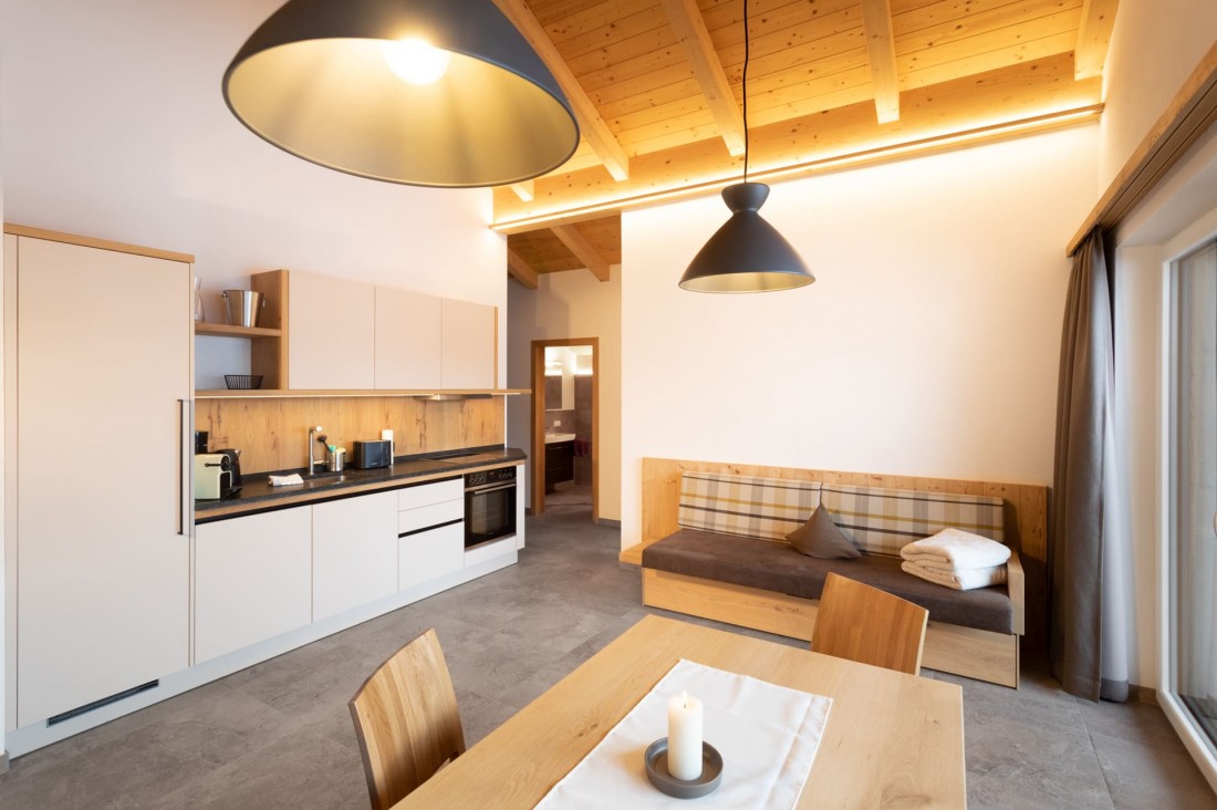 Wohnküche mit großem Esstisch im Penthouse-Apartment BergLeben Zaglauhof